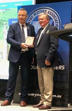 Two men standing next to each other

Description automatically generated