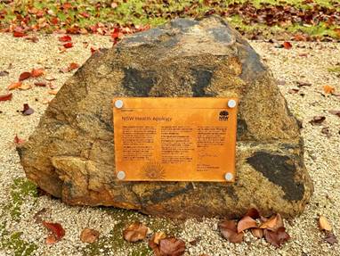 A rock with a sign on it

Description automatically generated